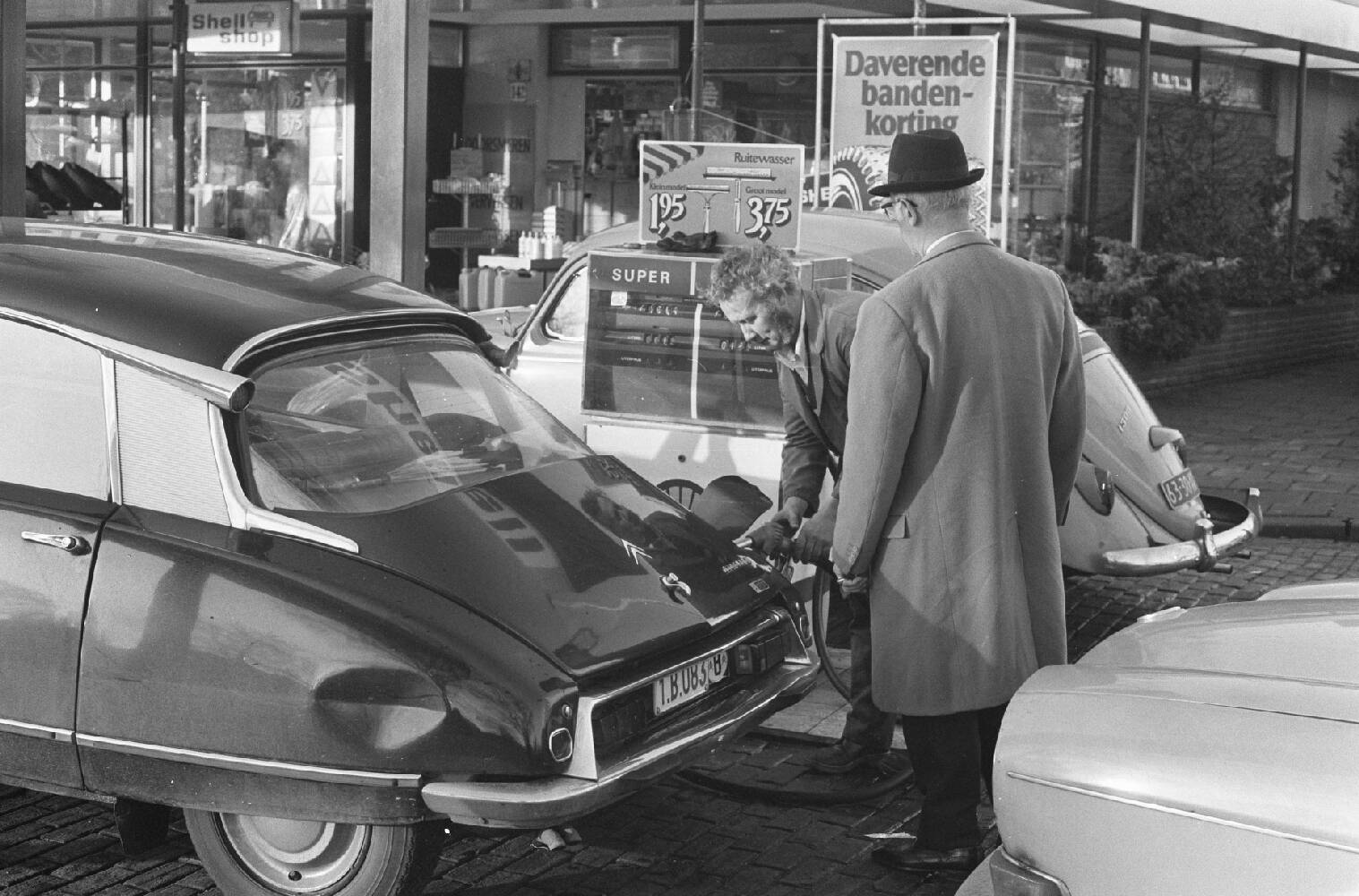 Pomphouders helpen klanten bij het tanken van benzine, een dag voor de start van de benzinedistributie, 11 januari 1974. Foto: Nationaal Archief/Anefo.