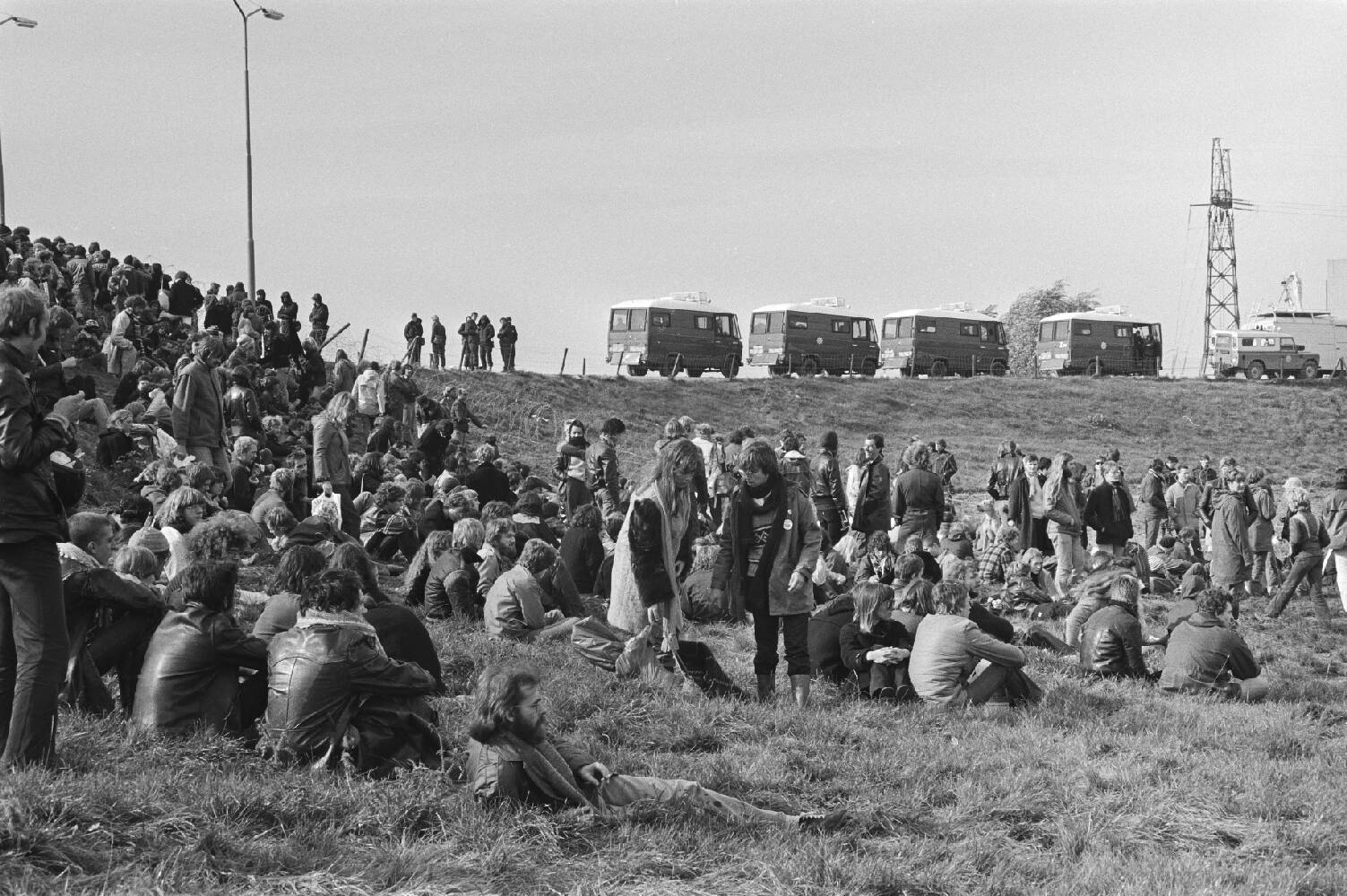 Actie Dodewaard moet dicht, demonstranten in het gras en ME-bussen op de dijk, 19 oktober 1980. Beeld: Hans van Dijk, Nationaal Archief/Anefo.